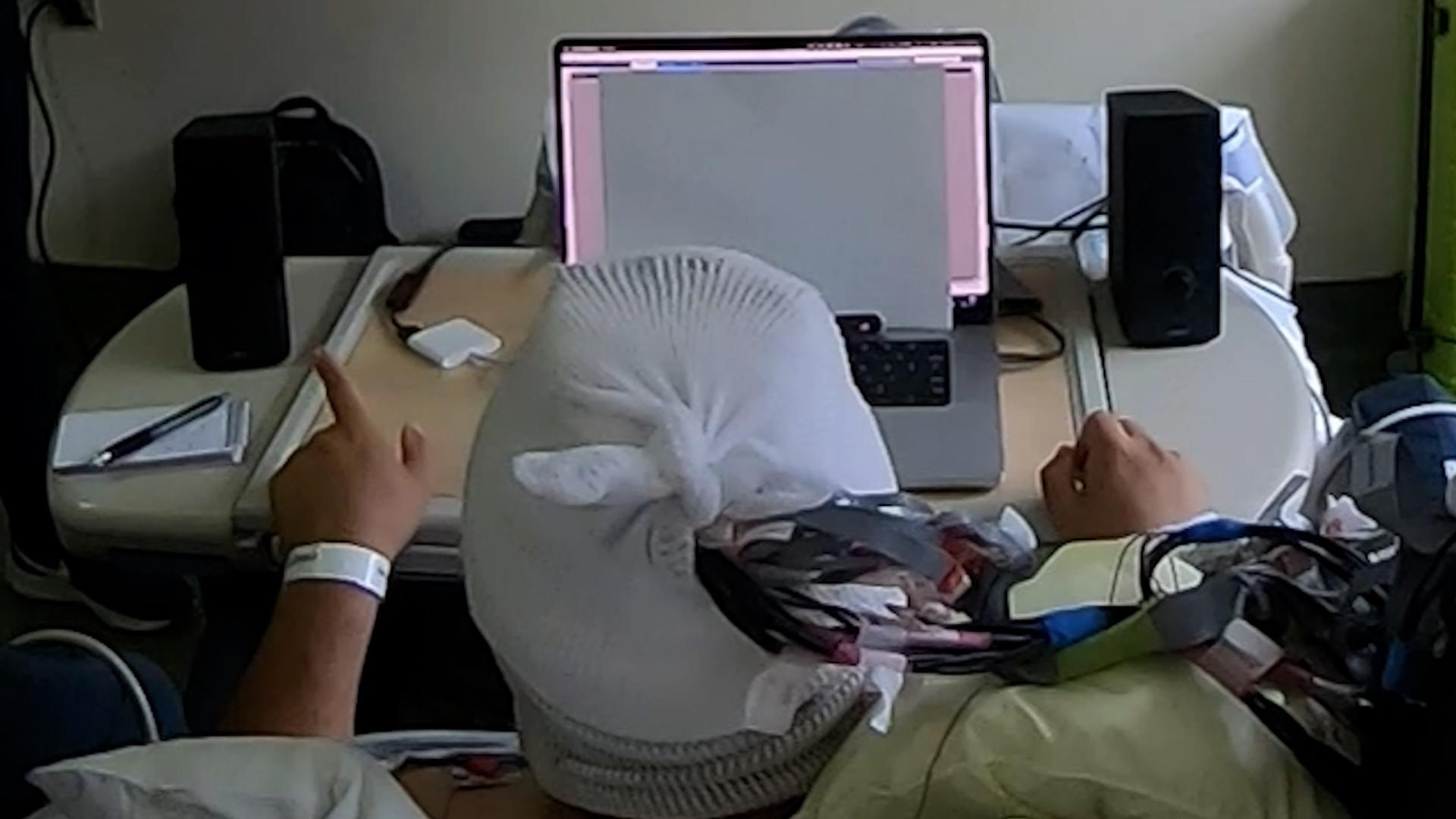El sistema auditivo monitorea la actividad cerebral del paciente, amplifica la conversación reproducida a su izquierda mientras atenúa la de su derecha, basándose en a qué conversación sugieren sus ondas cerebrales que está prestando atención. Fotografía facilitada por Vishal Choudhari / Laboratorio Mesgarani / Instituto Zuckerman de Columbia.
