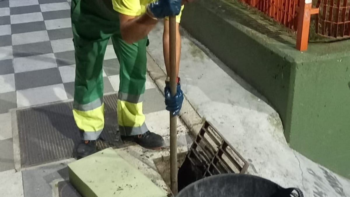 Equipo de limpieza municipal realizando labores de apertura y repaso de alcantarillado en la calle