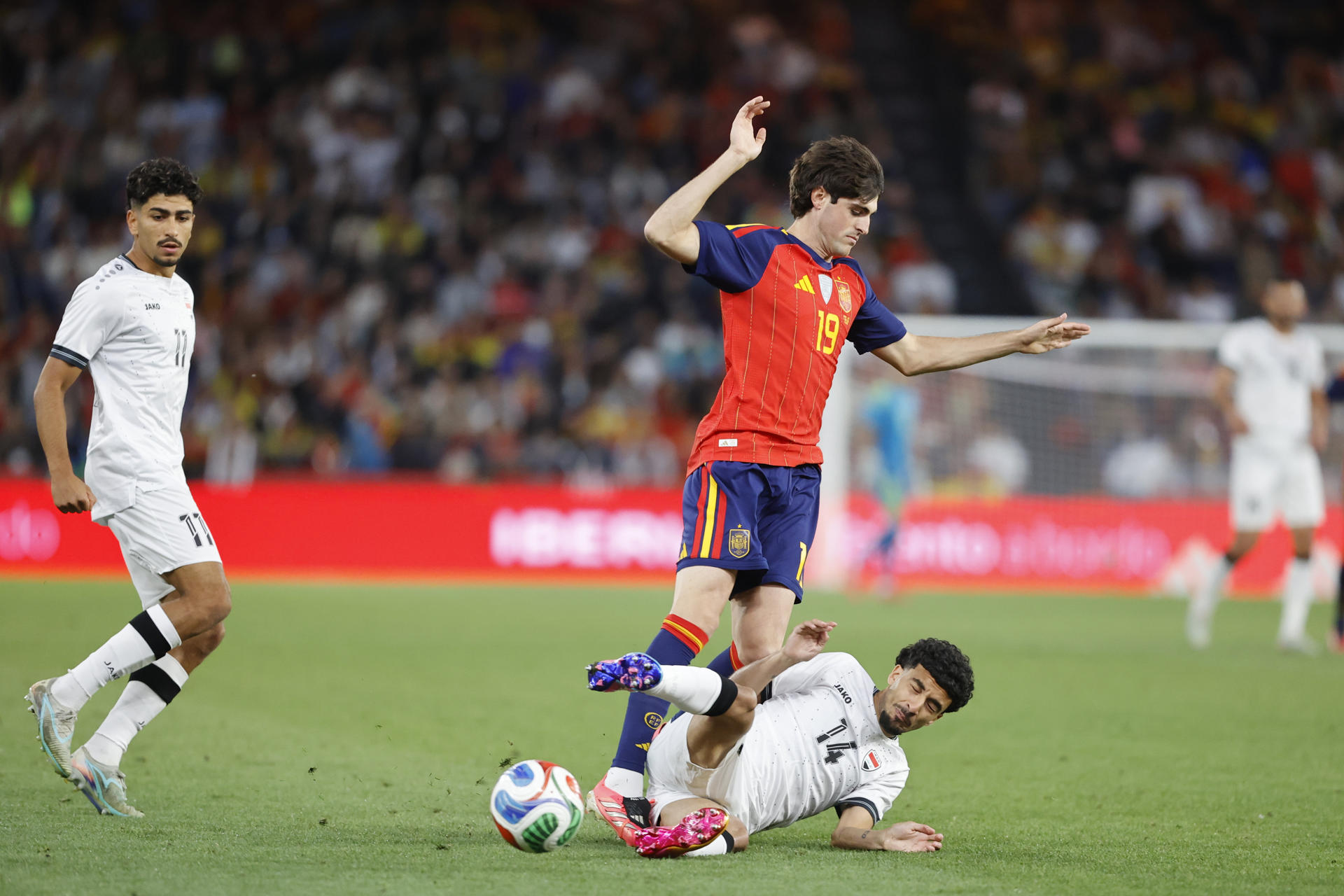 El centrocampista valenciano Javi Guerra (c) pelea un balón con Zidane Iqbal (d), de Irak, durante el partido amistoso de preparación para el Mundial que los combinados nacionales de España e Irak han disputado este jueves en el estadio de Riazor, en A Coruña. EFE/Cabalar