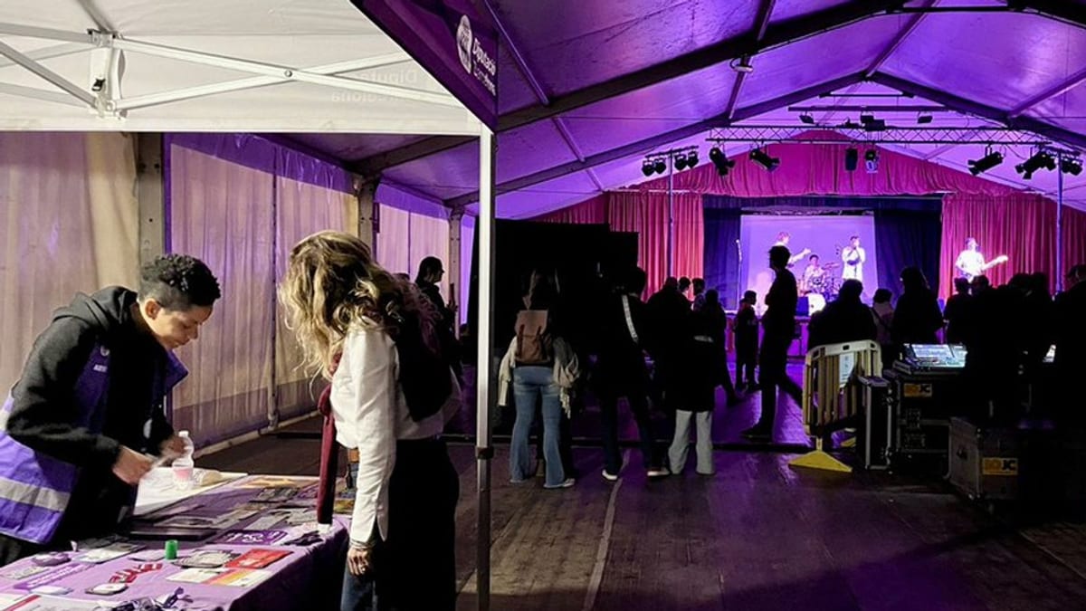 Evento de Punts Lila con escena principal y público bajo iluminación púrpura en espacios de ocio