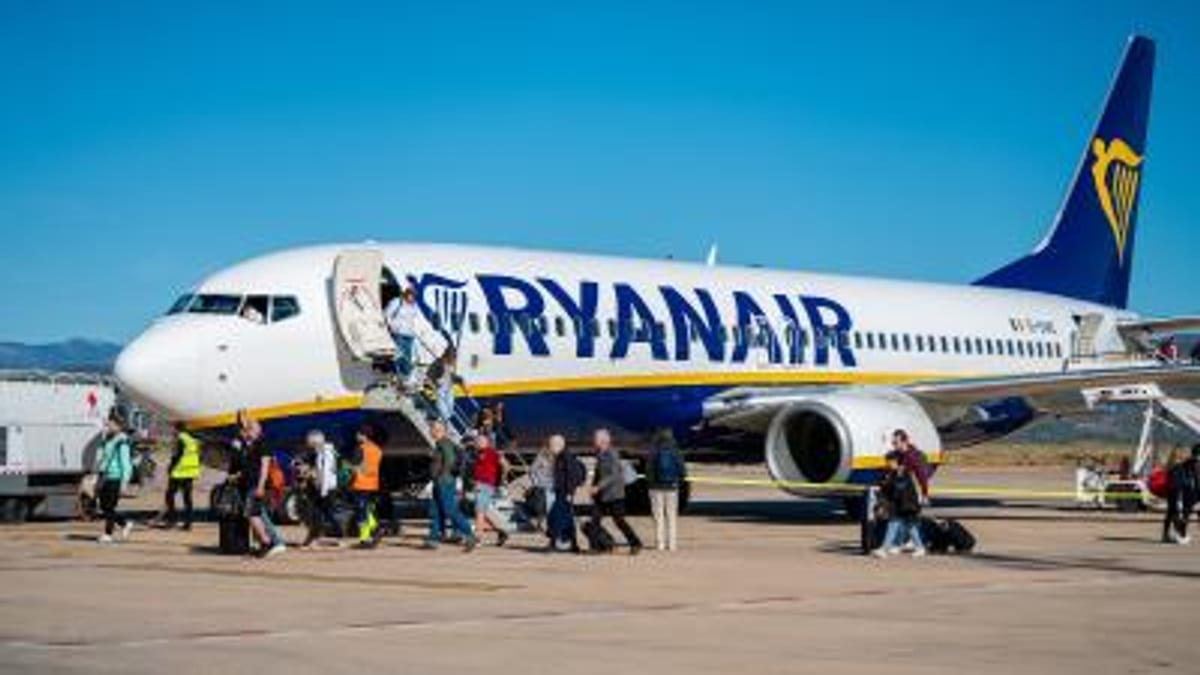 Avión Ryanair en pista de aeropuerto con pasajeros y personal de tierra