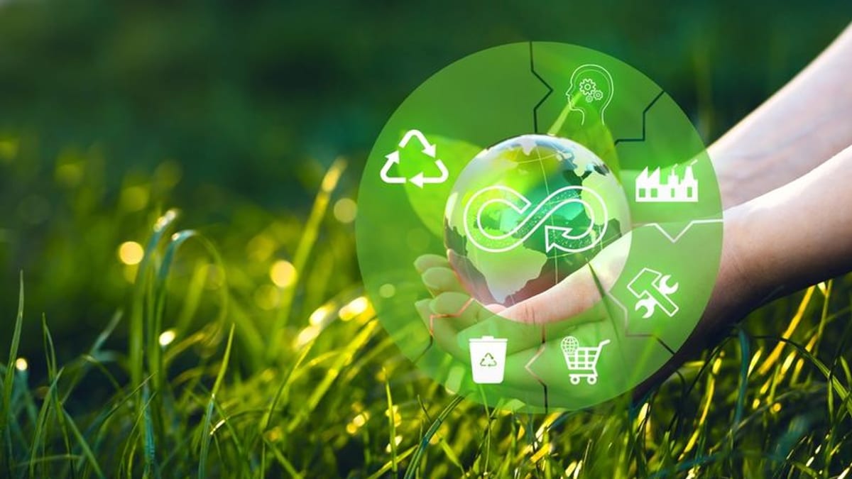 Símbolo de sostenibilidad con globo terráqueo en manos, rodeado de iconos de reciclaje, energía limpia y economía circular