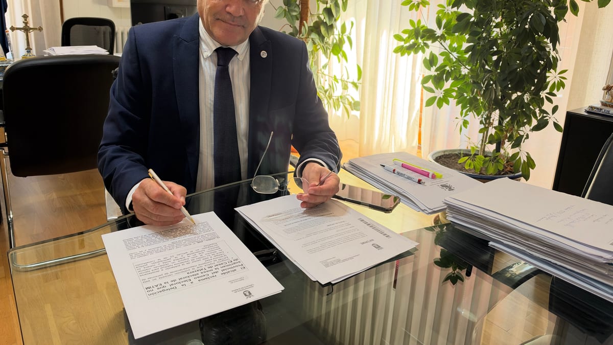 Hombre en despacho profesional trabajando con documentos sobre mesa de trabajo