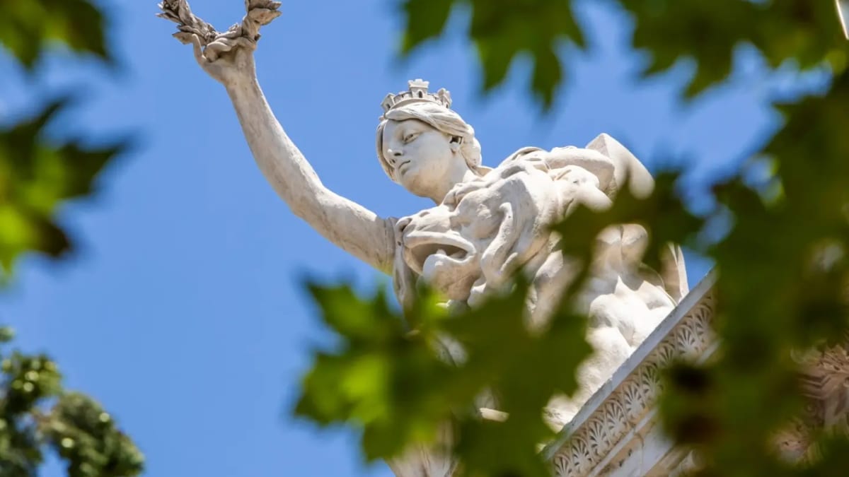 Frontón de la Biblioteca Nacional de España con la alegoría de España obra del escultor Agustín Querol, mostrando una figura que corona con laurel las obras de ingenio