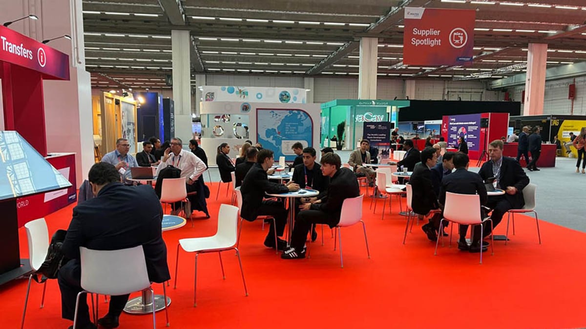 Stand de Andalucía en la feria Routes World con señalización de áreas de encuentro y contacto con aerolíneas