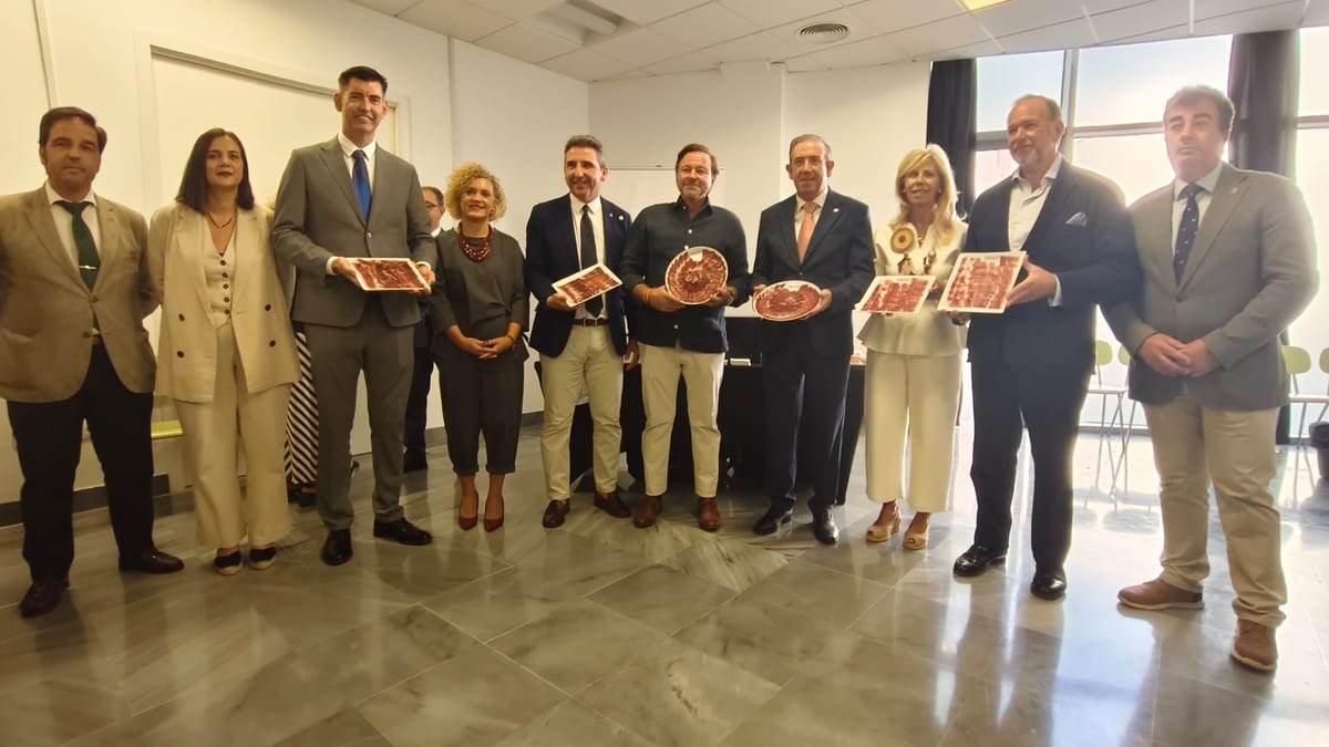 Inauguración de la XXIX Feria Regional del Jamón y del Cerdo Ibérico en Aracena con autoridades de la Diputación de Huelva y autoridades locales sosteniendo bandejas con jamón ibérico