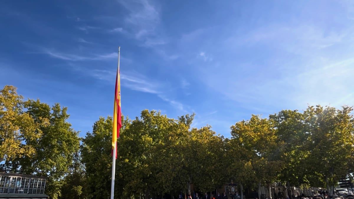 Ceremonia pública de conmemoración del Día de la Hispanidad en Aranjuez con ciudadanos reunidos alrededor de mástil con bandera