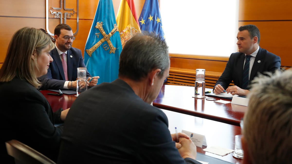 Reunión formal de autoridades y representantes del Gobierno del Principado de Asturias en sala de conferencias con banderas institucionales
