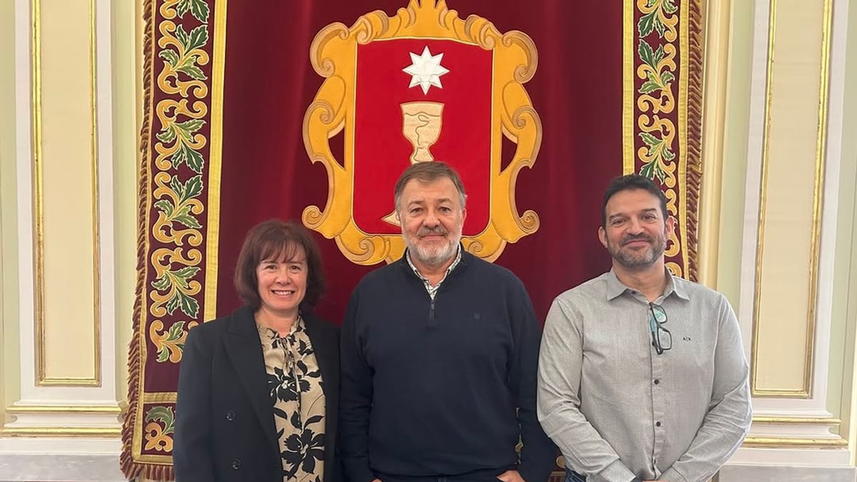Alcalde de Cuenca recibe al presidente de Adispo ante escudo heráldico
