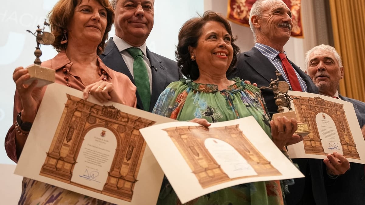 Ceremonia de homenaje a empleados públicos jubilados del Ayuntamiento de Sevilla, donde se observa a personas sosteniendo certificados y estatuillas de reconocimiento