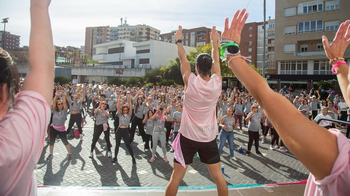 Participantes en la edición de Baila contra el cáncer de mama en Badajoz, mostrando mensajes de solidaridad y concienciación