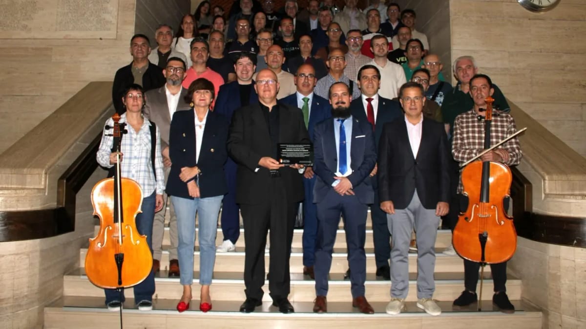 Miembros de la Banda Sinfónica Municipal de Albacete posando en una escalera con instrumentos musicales
