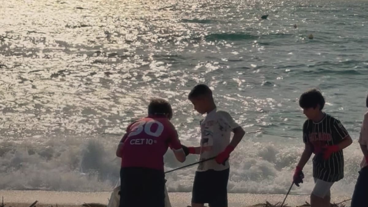 Jornada de limpieza colaborativa en Barcelona con escolares recogiendo residuos en una playa, promovida por el Pla Endreça