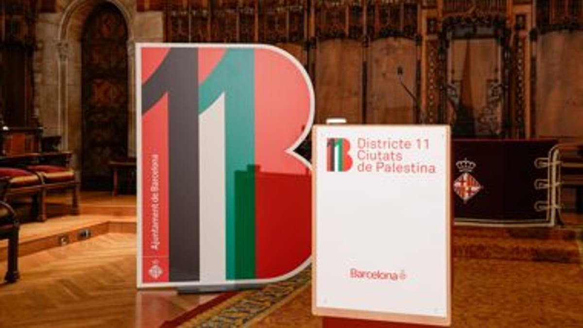 Señalización del Distrito 11 de Barcelona con mensaje de solidaridad con Palestina