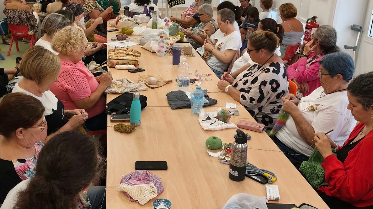 Grupo de personas reunidas alrededor de una mesa en la Biblioteca Adolfo Suárez de Cádiz durante el encuentro de Yoganchillo Cádiz y Punto: Leer y tejer