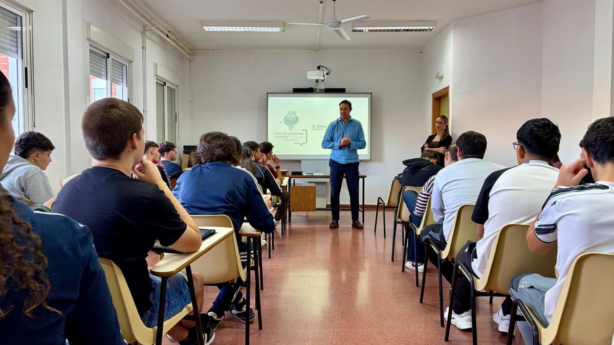 Sesión informativa del Plan Local de Juventud de Cáceres 2026-2029 en un colegio, con presentación proyectada y participación de estudiantes