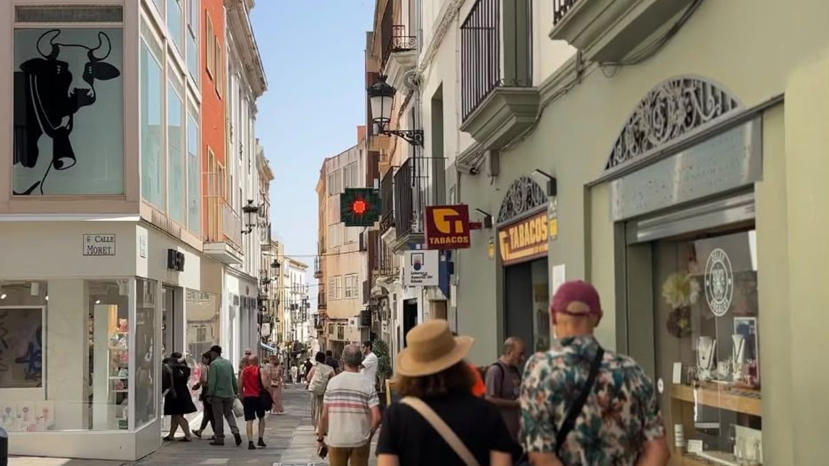 Turistas visitando las calles monumentales de Cáceres, con fachadas históricas de piedra