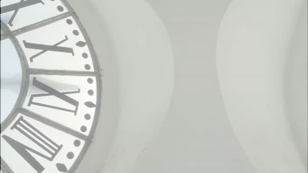 Reloj analógico con números romanos en el techo blanco del Ayuntamiento de Valencia