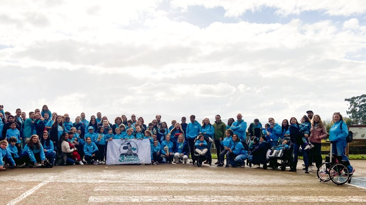 Grupo de más de 40 niños y familias visitando el Parque de la Naturaleza de Cabárceno, vistiendo camisetas azules en una foto de grupo
