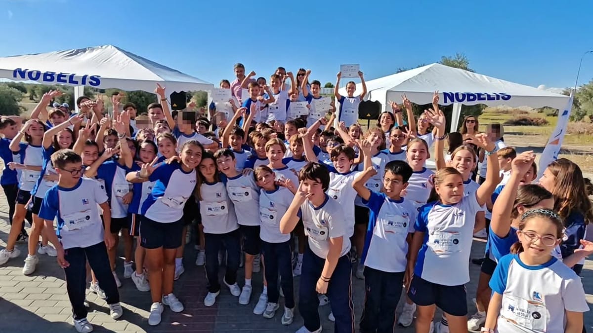 Participantes en la carrera solidaria del Colegio Nobelis y Valle del Miro en Valdemoro, con sombrillas y cartelería de la iniciativa contra la leucemia infantil