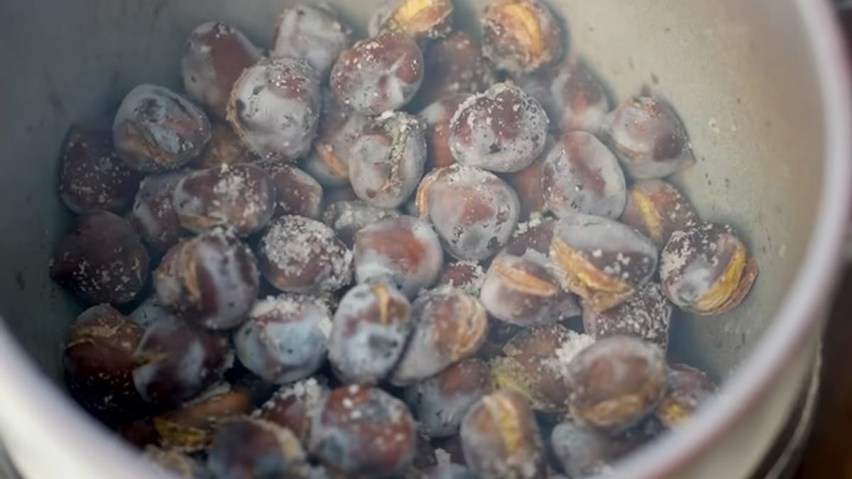 Puesto ambulante de castañas asadas en Málaga con cartel indicativo durante la temporada otoñal