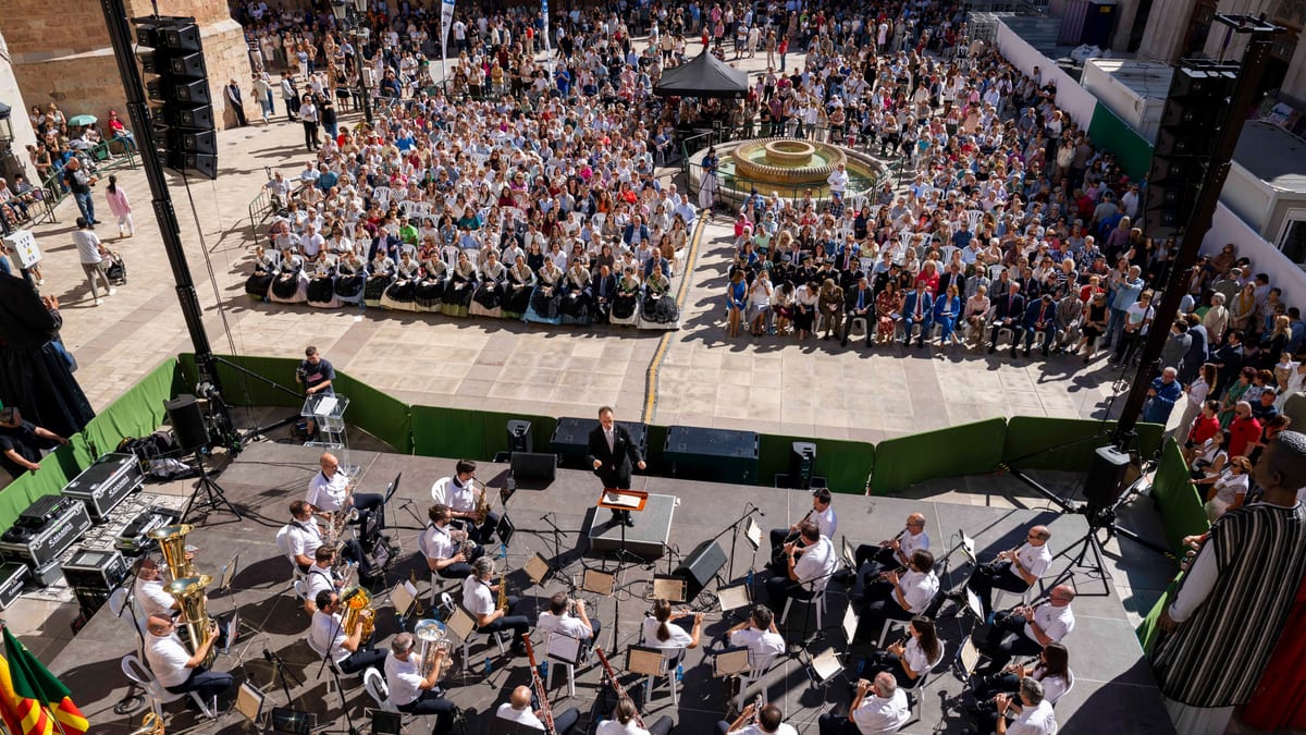 Vista aérea de un evento en la plaza de Castellón con una orquesta en el escenario y multitud de personas celebrando el 9 de Octubre