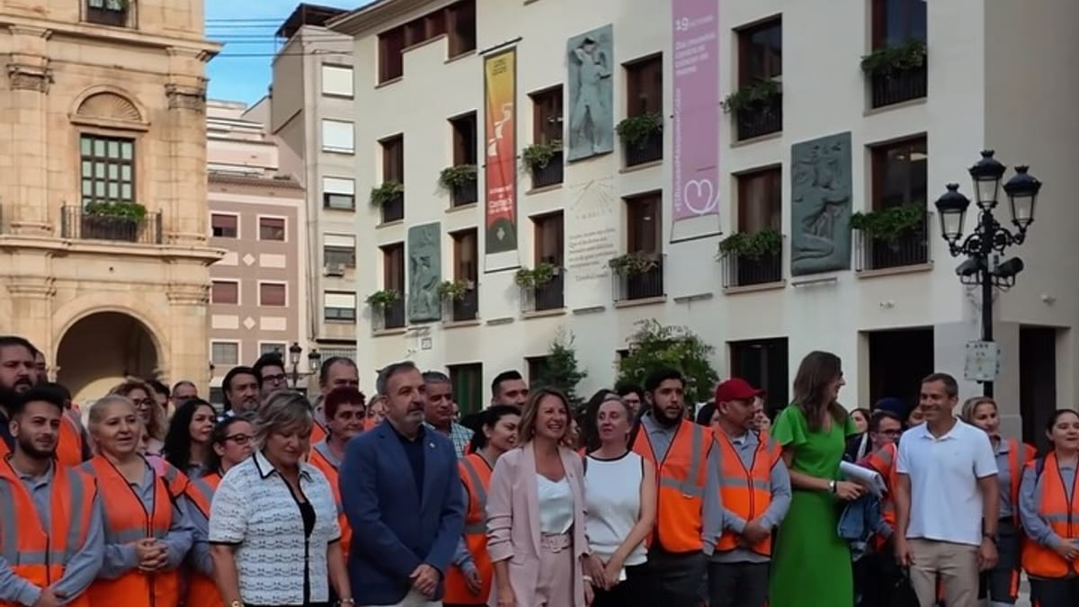 Grupo de trabajadores con chalecos de seguridad naranja en la Plaza Mayor de Castellón durante el inicio del Plan Propio de Empleo