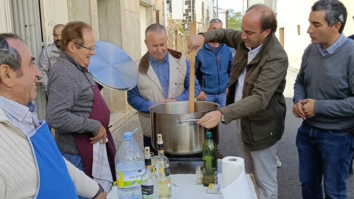 Participantes en la Fiesta Reivindicativa del Cordero y Lechazo de Burgos alrededor de una olla con productos tradicionales