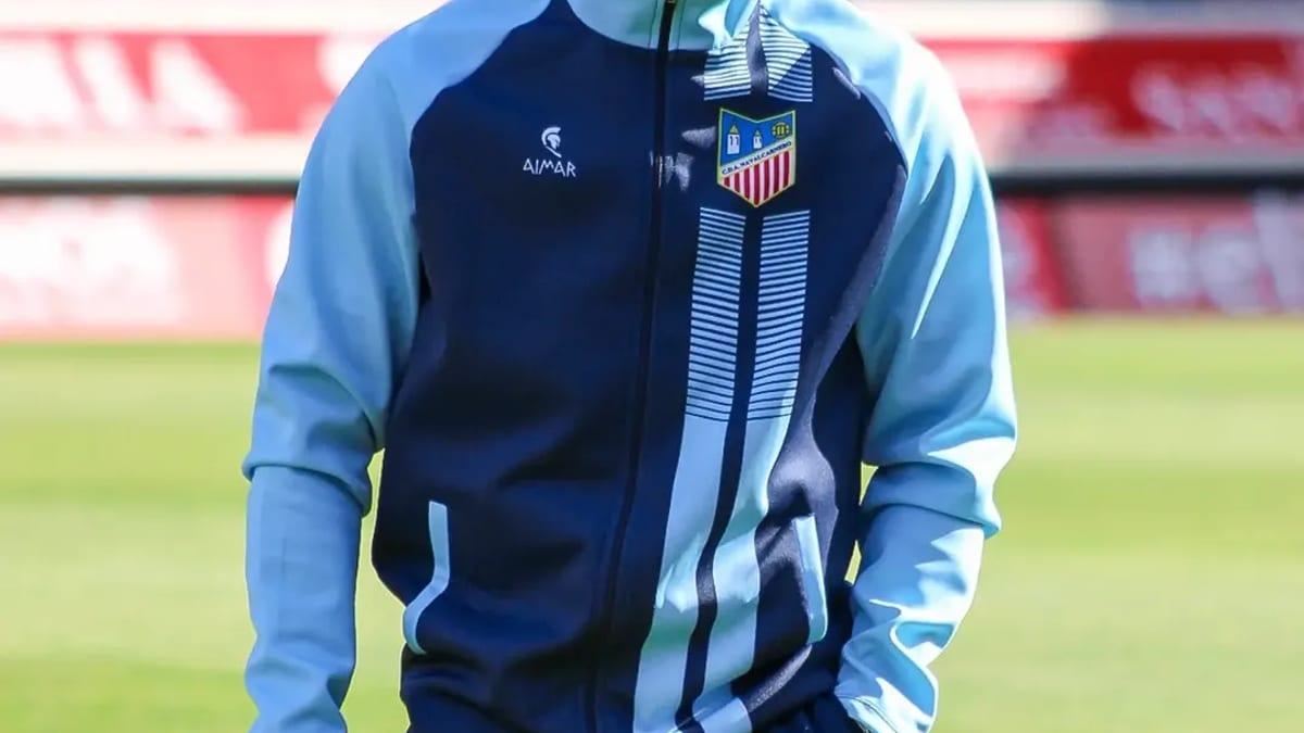 Jugador del CD Navalcarnero en el Estadio Los Pajaritos vistiendo chándal azul marino con escudo de competición