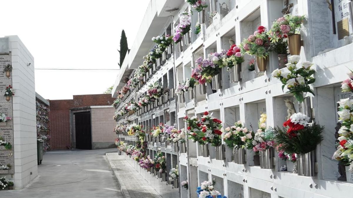 Vista del cementerio municipal con nichos blancos decorados con flores de colores para el Día de Todos los Santos