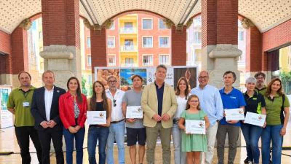 Grupo de personas posando con certificados en acto oficial de la Mostra de la Marca Parcs Naturals en edificio de arquitectura neoclásica