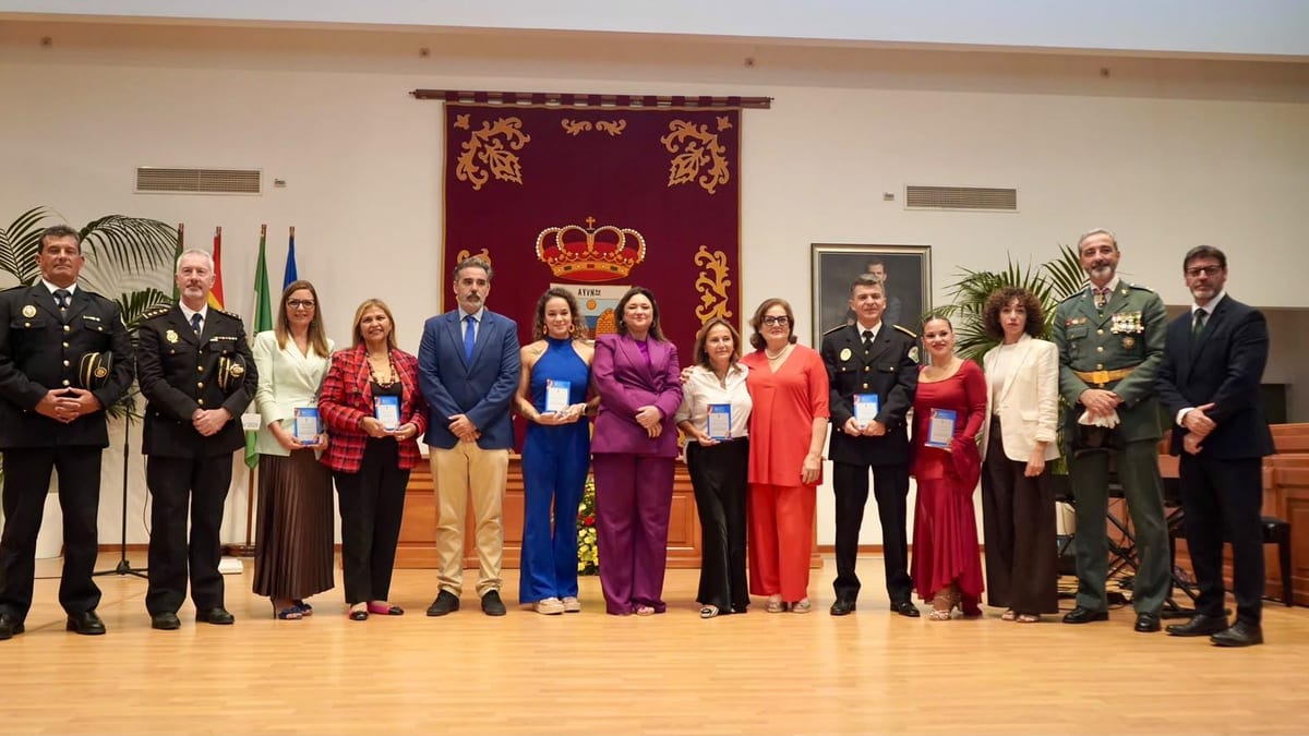 Acto oficial de conmemoración del cincuenta aniversario del Premio Cervantes a Jorge Guillén en Torremolinos, con autoridades municipales posando para fotografía formal ante escudo heráldico y banderas