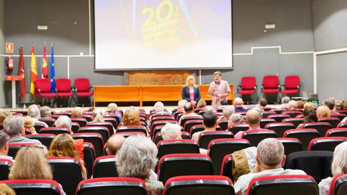 Sala de conferencias del Cinefórum Chaplin en Aguirre con asistentes, panel de presentadores y pantalla de proyección