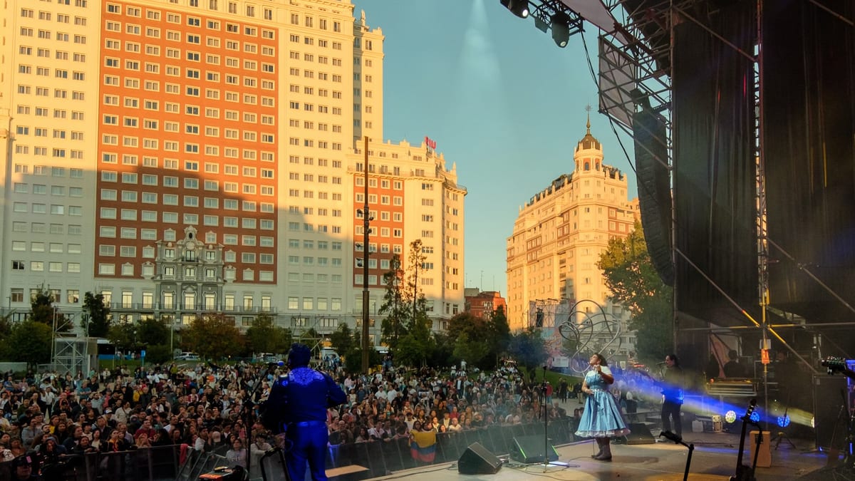 Concierto en vivo en una plaza pública de Madrid durante el evento de Hispanidad2026, con edificios históricos de fondo