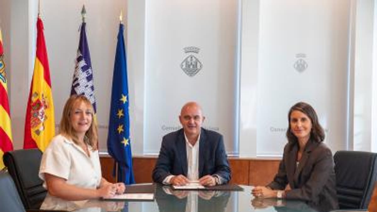 Firma del convenio entre representantes del Consell d'Eivissa y el Ajuntament de Sant Joan de Labritja con banderas españolas y europeas de fondo