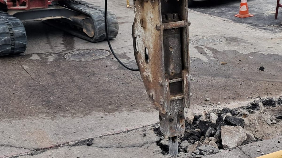 Maquinaria pesada y vehículos en zona de obras con barrera de seguridad