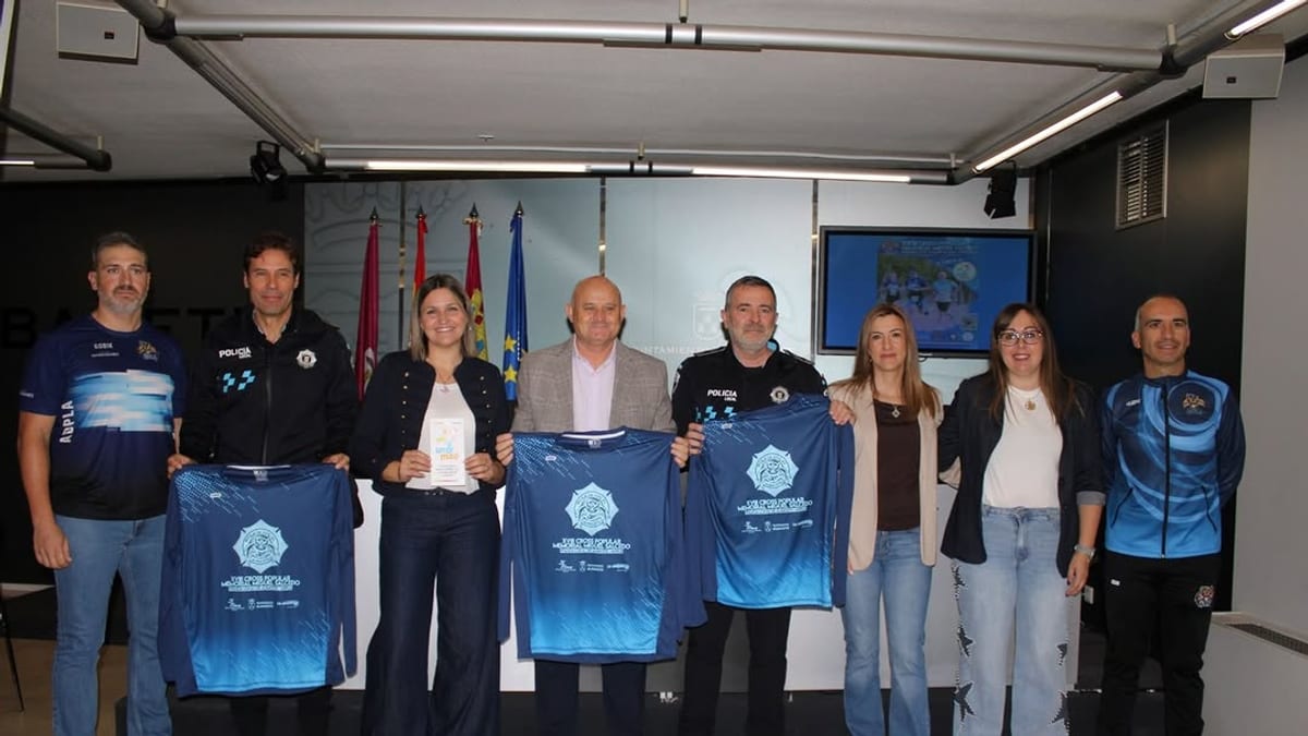 Grupo de autoridades y miembros de ADPLA en evento deportivo de Albacete sosteniendo camisetas azules con logo oficial