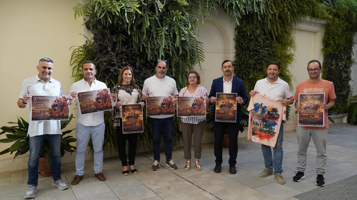 Grupo de personas sosteniendo carteles de promoción de la Carrera Snell El Campillo 'Un reto compartido'