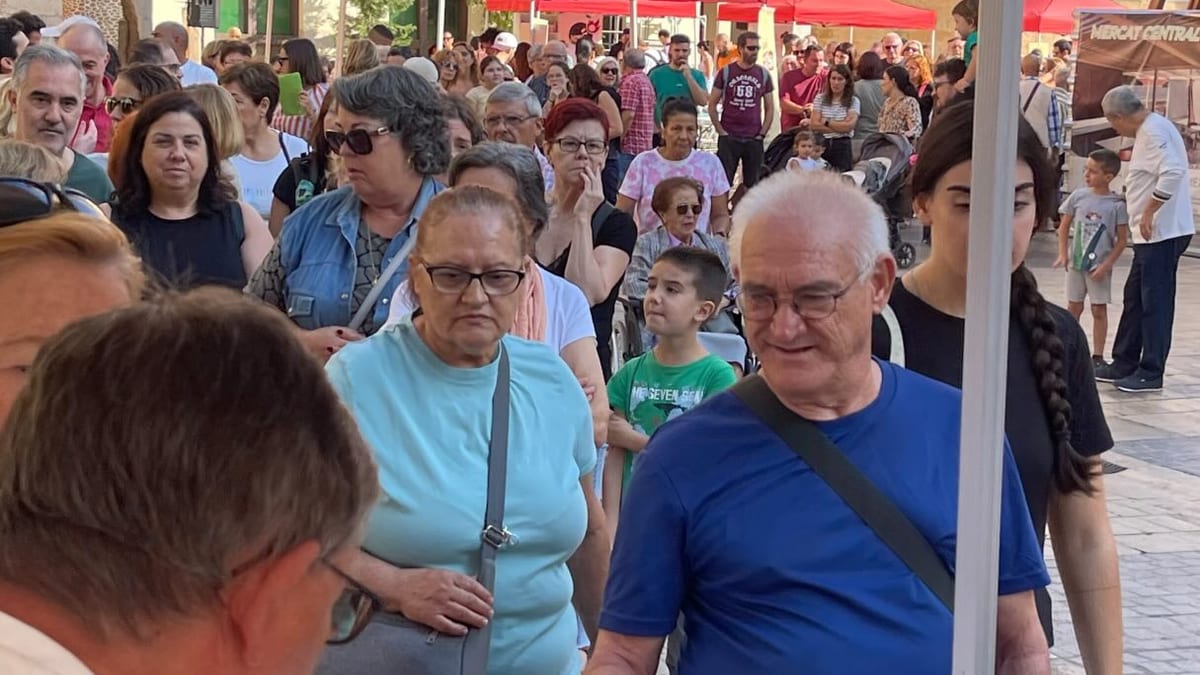 Evento del Día Mundial del Pan en la Plaza de la Pescadería de Castellón con asistentes, carpas y mesa con productos artesanales