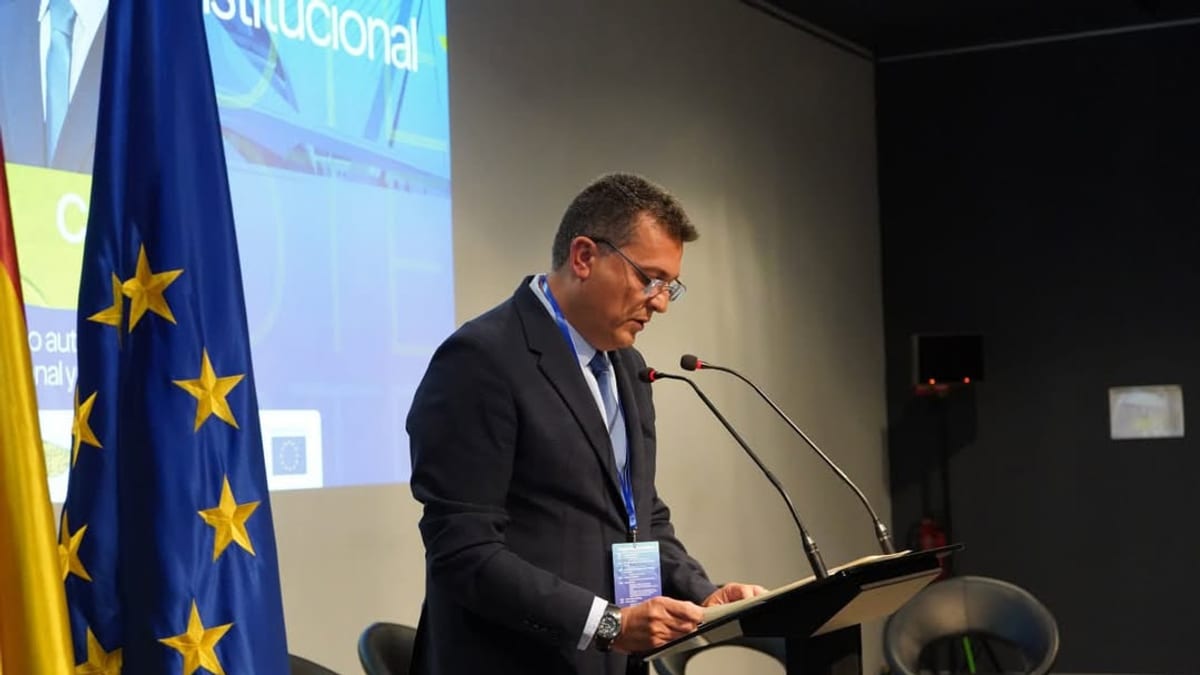Presentación de la Academia de Participación Ciudadana de Partenalia con representante de la Diputació de València ante micrófono y bandera europea de fondo
