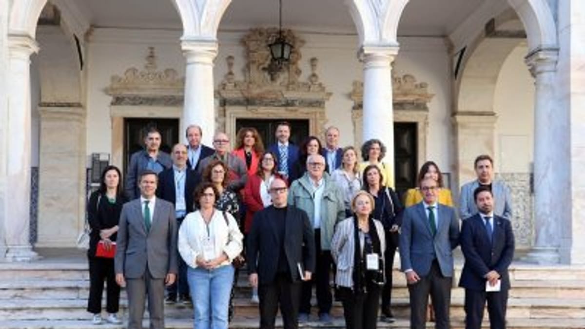 Representantes de instituciones posando en la firma oficial del convenio de 'La frontera de la cultura' frente a edificio con arquitectura clásica