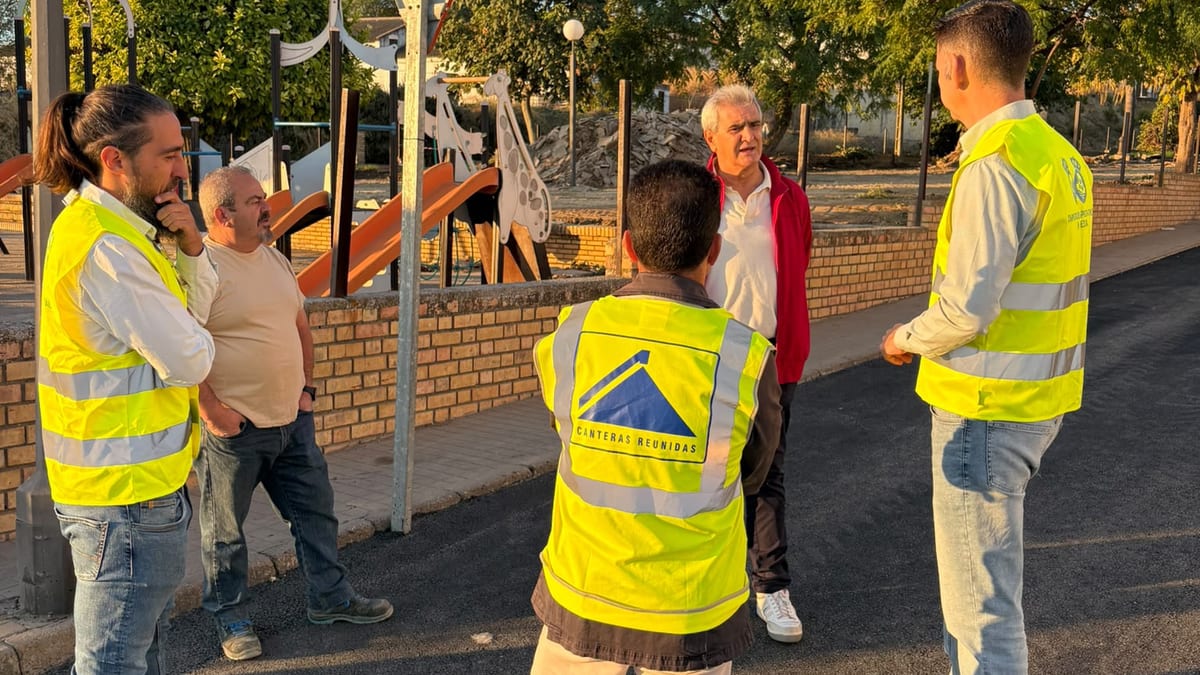 Supervisor y trabajador en chaleco amarillo durante inspección de obras de asfaltado en Escacena del Campo