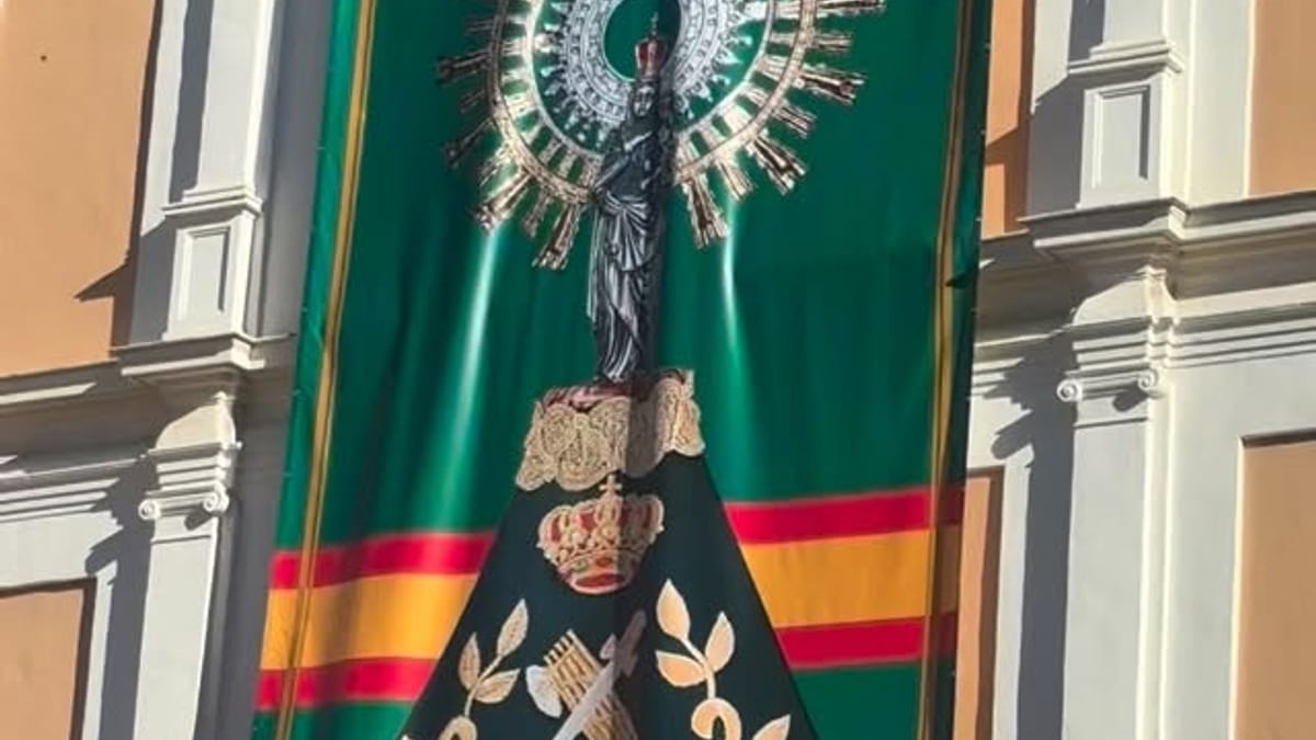 Estandarte decorativo con motivos religiosos colgado en fachada durante celebración del Día del Pilar en Huelva