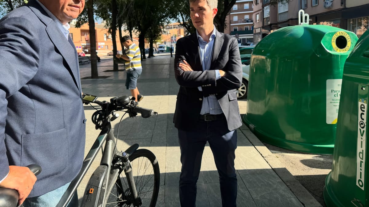 Educadores ambientales de Ecovidrio en plaza urbana con contenedores de reciclaje verde