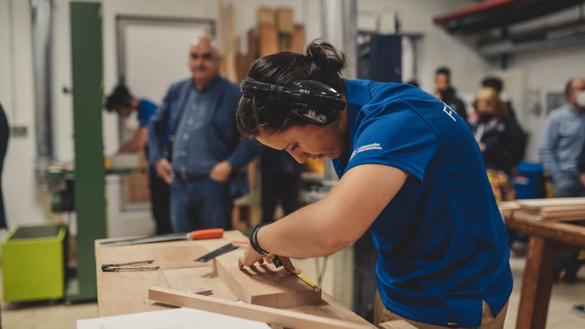 Taller de carpintería en la feria Edugal de Pontevedra con personas aprendiendo técnicas de trabajos en madera