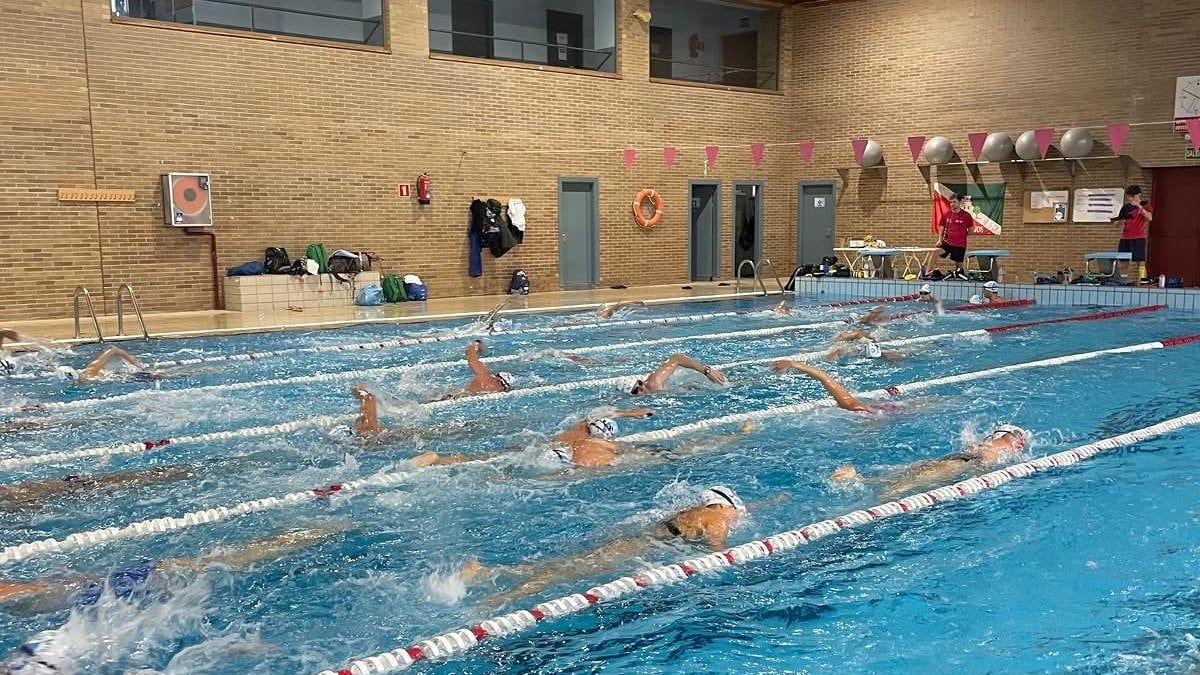 Piscina cubierta con nadadores entrenando en diferentes carriles durante las Escuelas Deportivas Municipales de Torrijos
