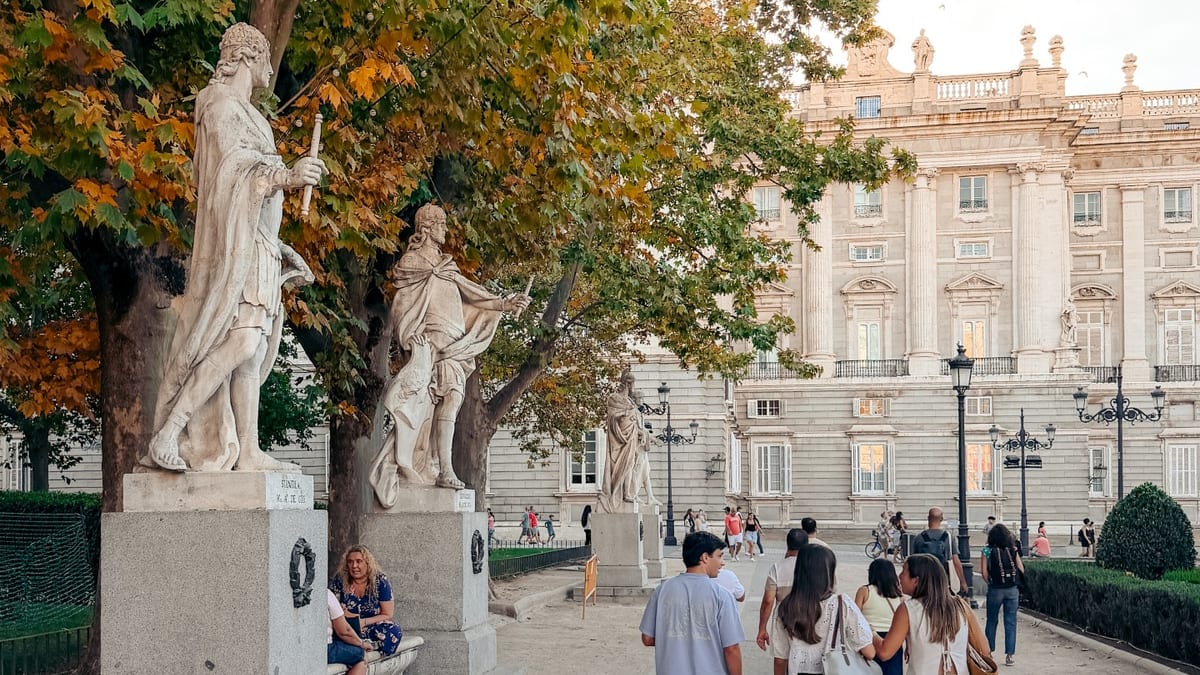 Estatuas de la Plaza de Oriente con el Palacio Real de Madrid de fondo en una vista de los jardines históricos