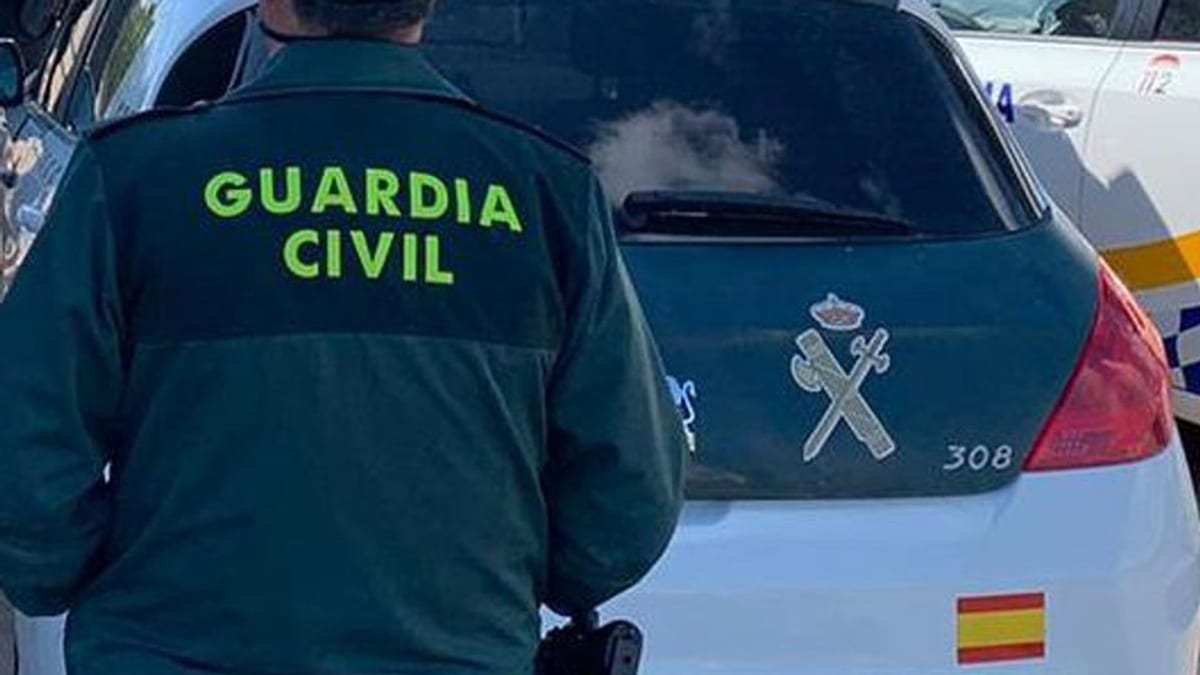 Agente de la Guardia Civil junto a un vehículo oficial de emergencias