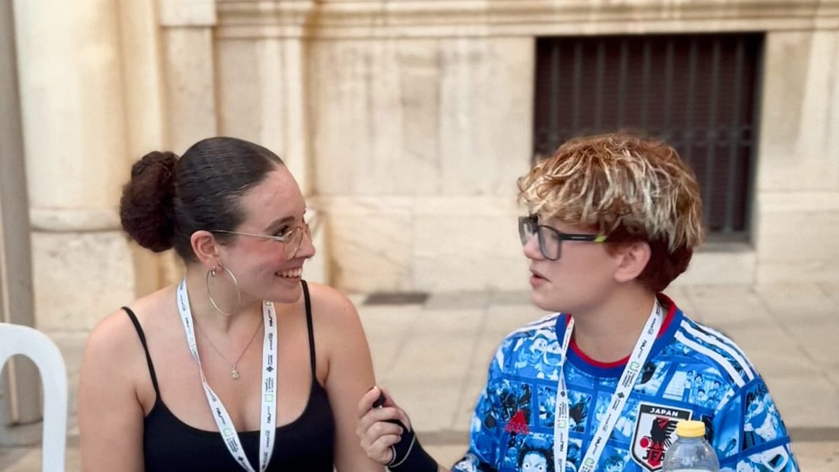 Dos personas en una mesa de la Feria de Entidades Juveniles de Castellón con materiales informativos sobre asociaciones juveniles