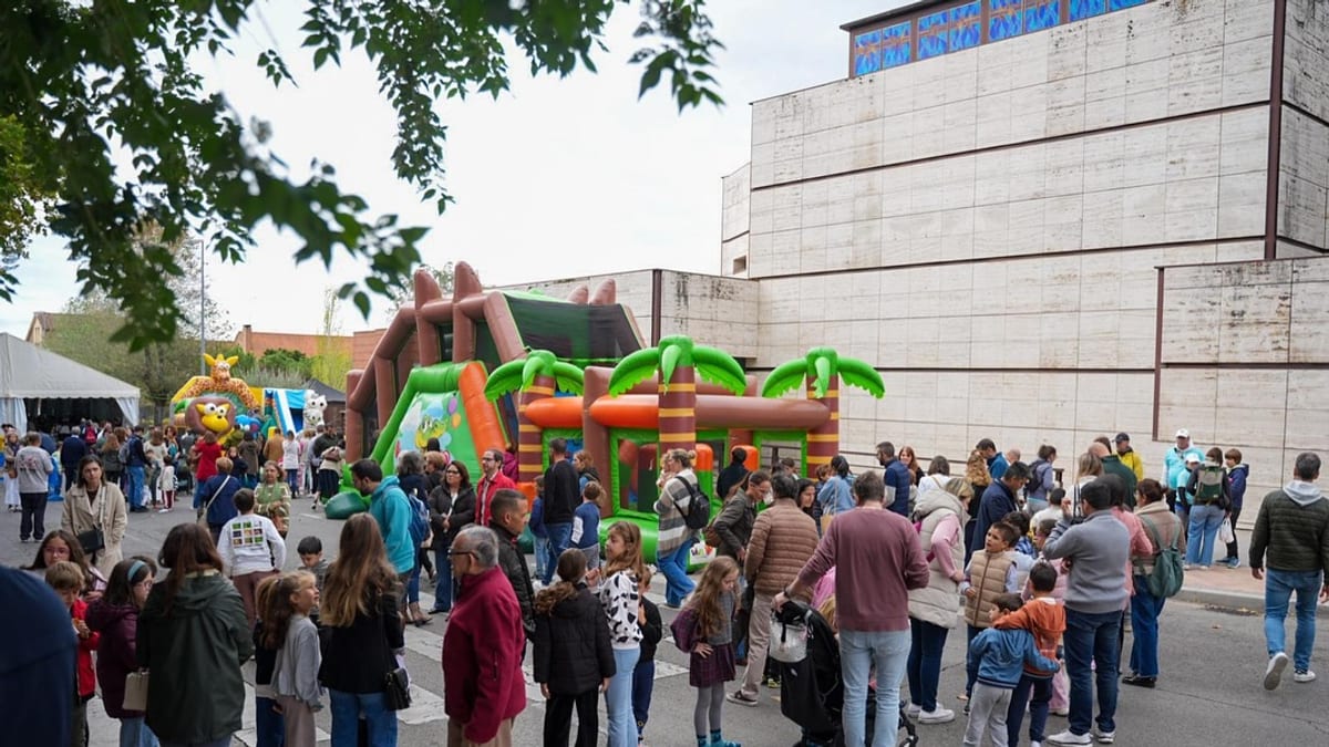 Evento festivo en Santa Teresa con inflables y numerosas personas disfrutando de las actividades en el barrio de Colmenar Viejo